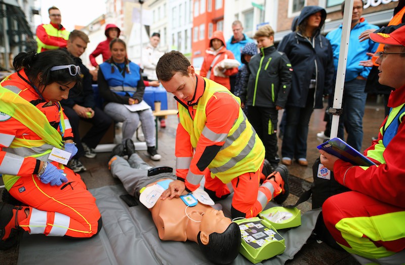 Young first aiders conduct CPR on a training mannequin.
