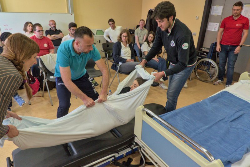 TeilnehmerInnen eines I_TEM Pilottrainings üben den schnellen Transfer einer Patientin vom Bett auf eine Trage.